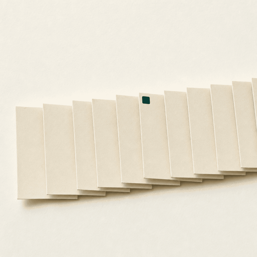 A long fan of identical cream-paper consultation slips overlapping in a row that extends off the right edge of the frame — more than you can count, the row never ends.